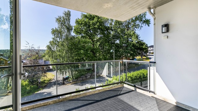 Balkongens ca. 11 kvm. er helhetlig utført med plastfliser og pent innrammet av glassrekkverk som ivaretar både sol- og utsiktsforholdene.