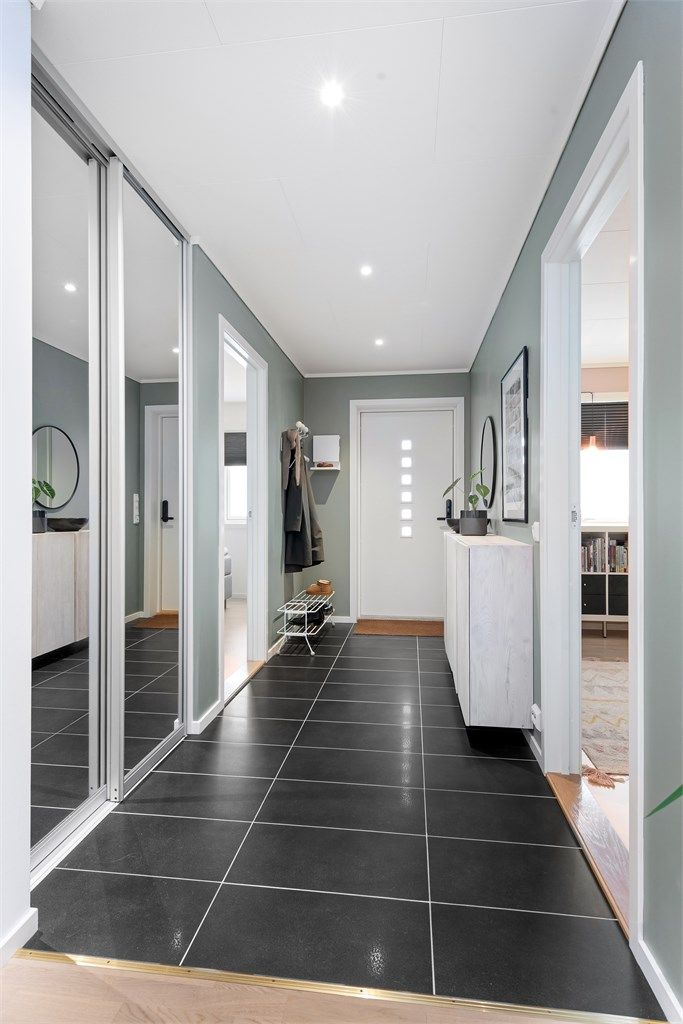 Velkommen inn i en romslig entré med flislagt gulv og god plass til oppbevaring.