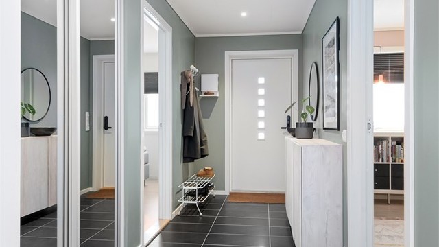 Velkommen inn i en romslig entré med flislagt gulv og god plass til oppbevaring.