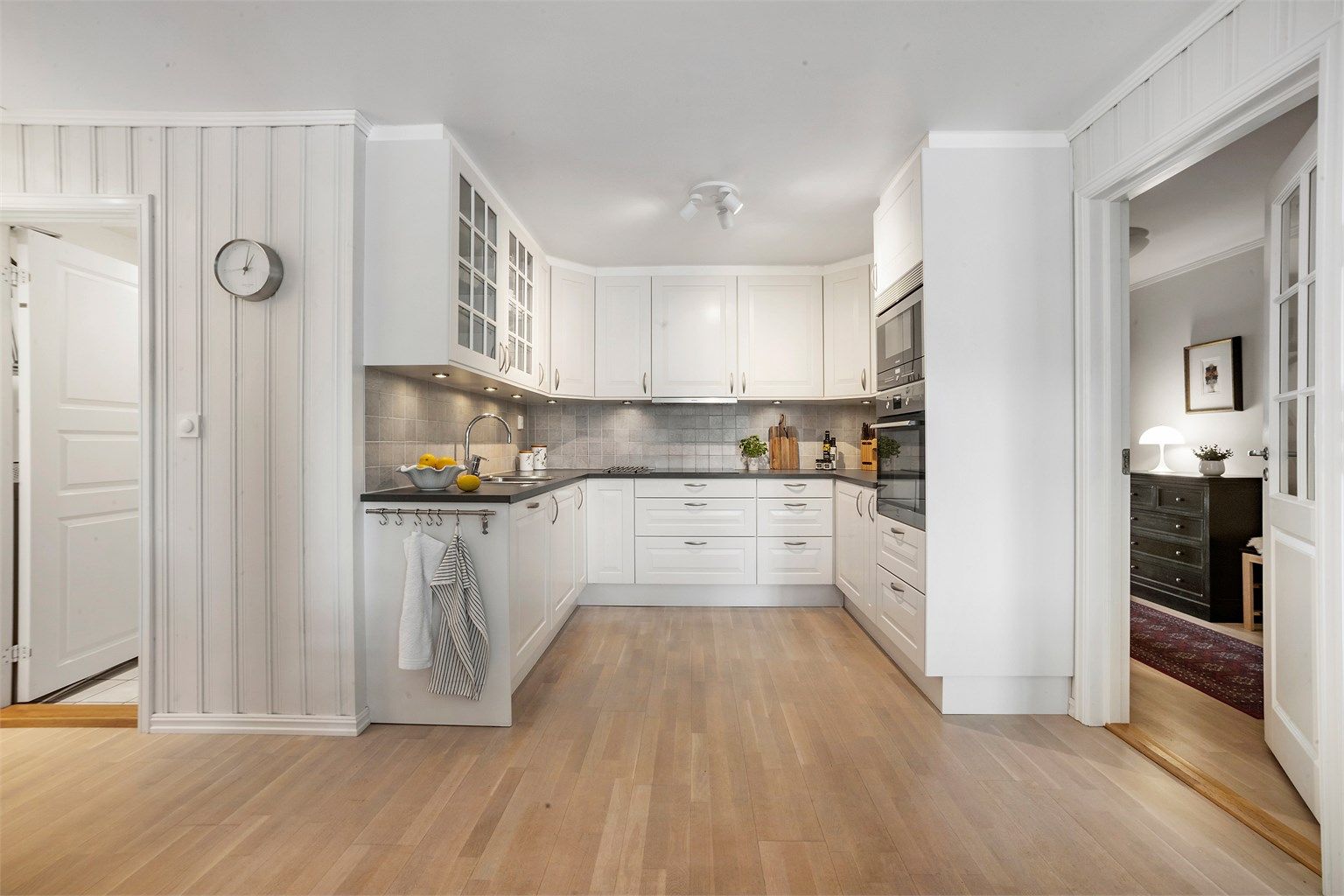 Lys kjøkkeninnredning fra 2009 av typen Marbodal med klassiske, profilerte fronter og laminatbenkeplate.