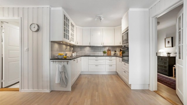 Lys kjøkkeninnredning fra 2009 av typen Marbodal med klassiske, profilerte fronter og laminatbenkeplate.