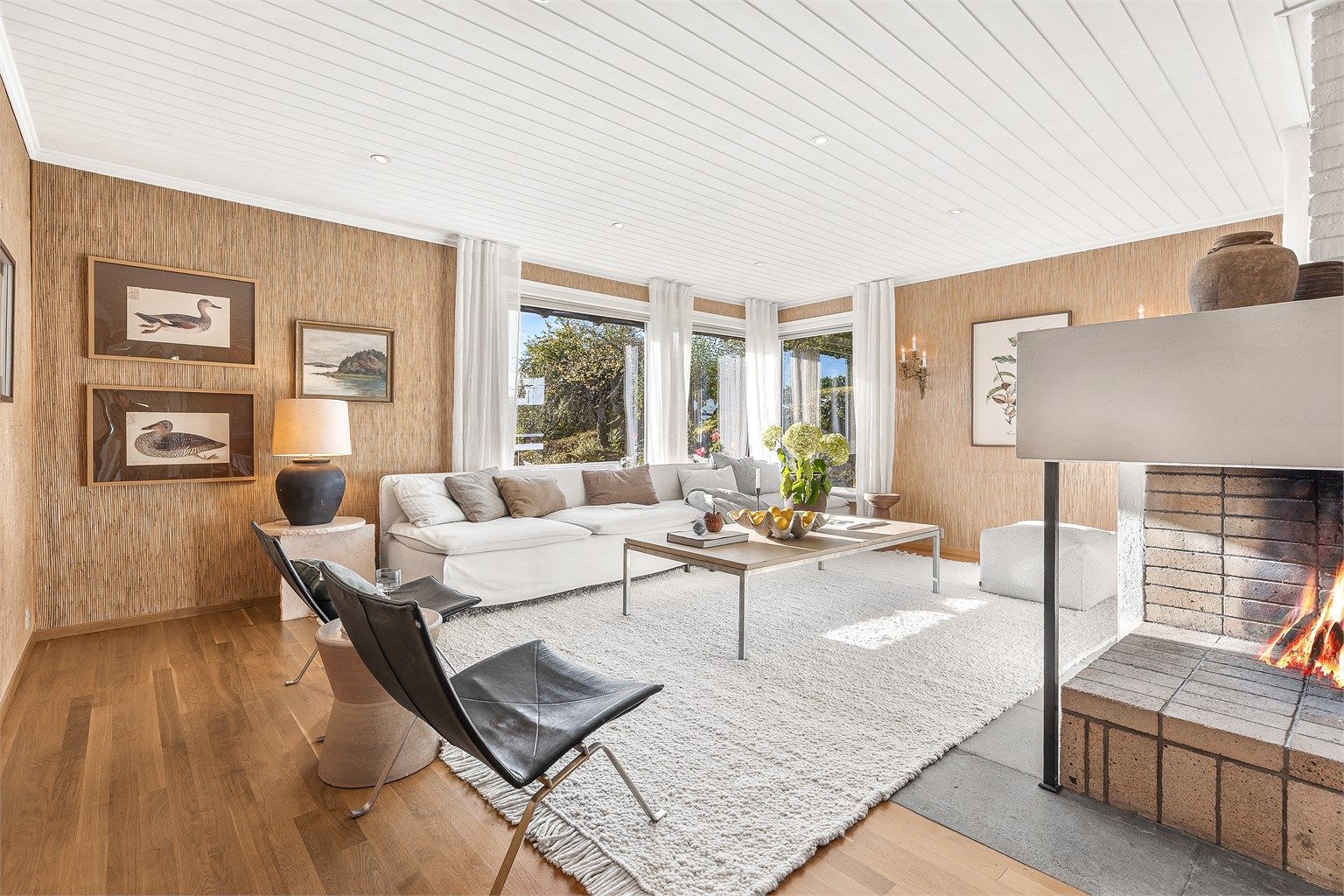 Lys og luftig stue med hyggelig peis midt i rommet og adkomst til terrasse