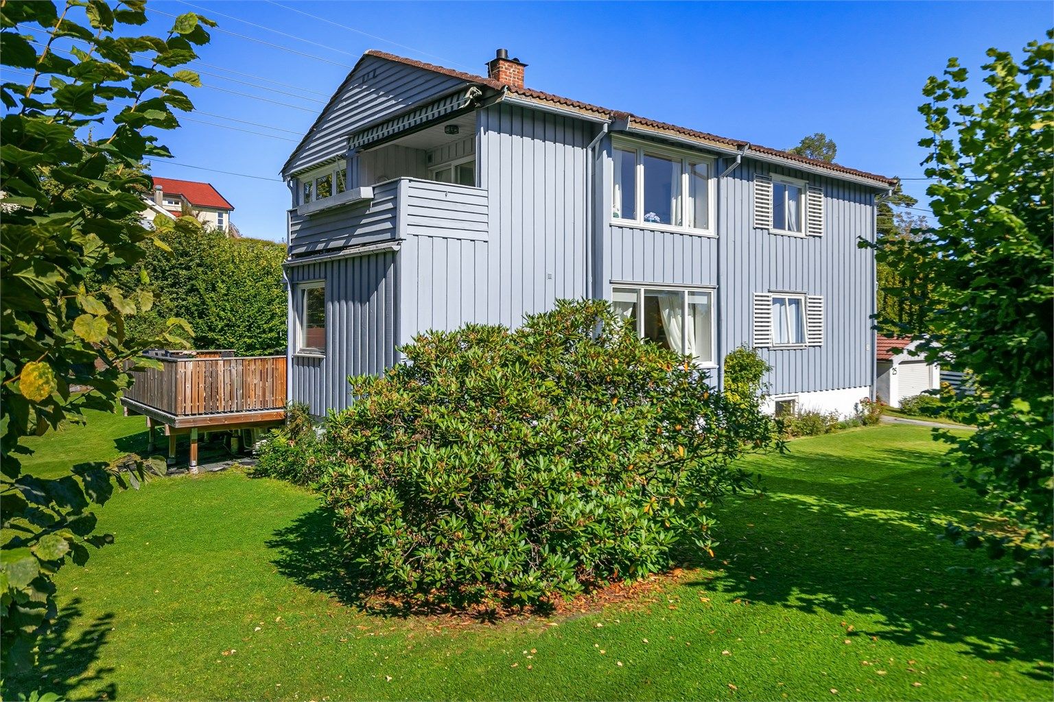 Boligen har uteplasser på flere nivåer med terrasse i første etasje og balkong i andre etasje.