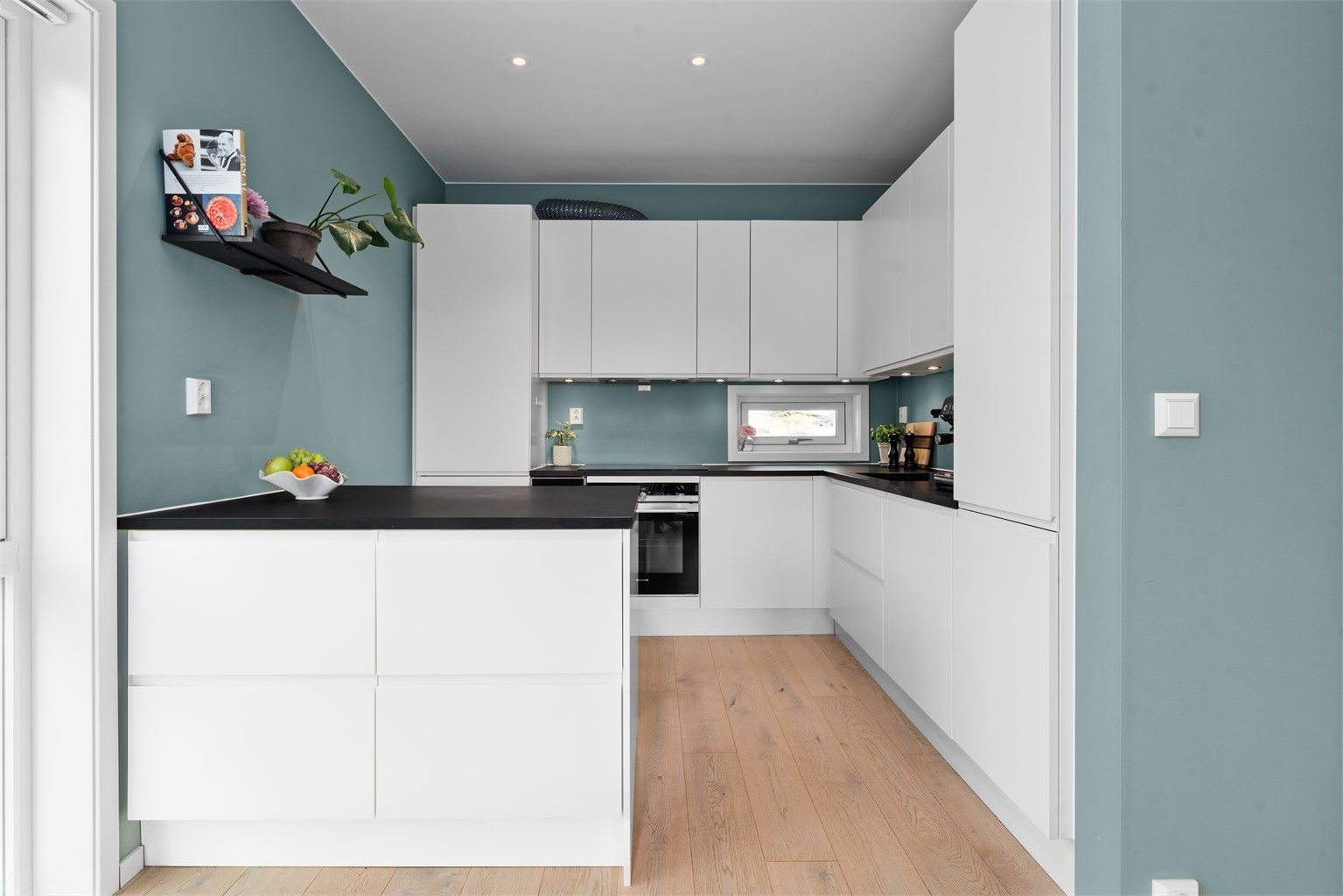 Kjøkkenet har en funksjonell form med rikelig skap- og benkeplass. Det er integrert vinskap, komfyr, platetopp og kjøl/frys. 