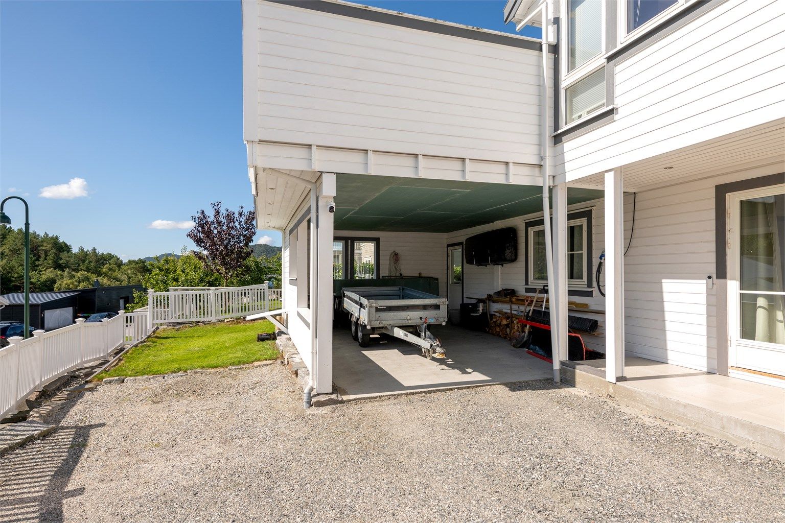 Integrert carport med støpt dekke og overbygget adkomst mot boligen.
