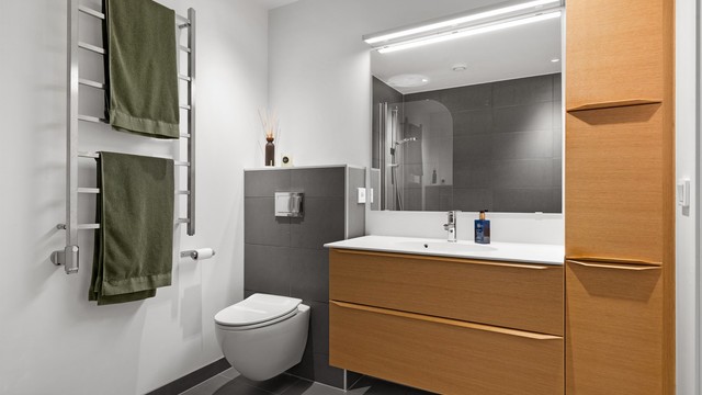 Også dette badet har flislagt gulv med gulvvarme og innfelt spottbelysning