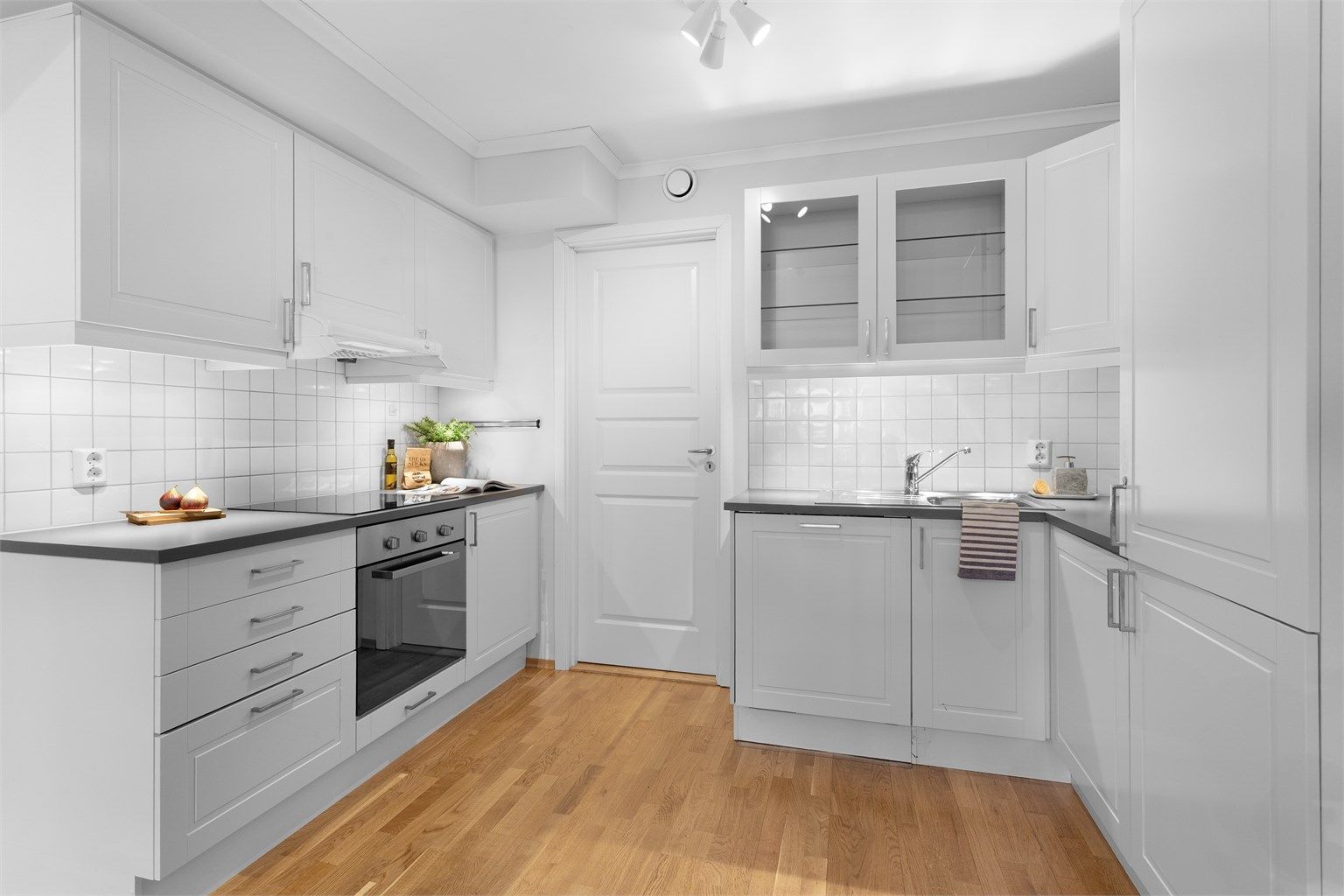 Kjøkken med innredning med profilerte fronter. Benkeplate med laminert overflate med nedfelt kjøkkenvask.