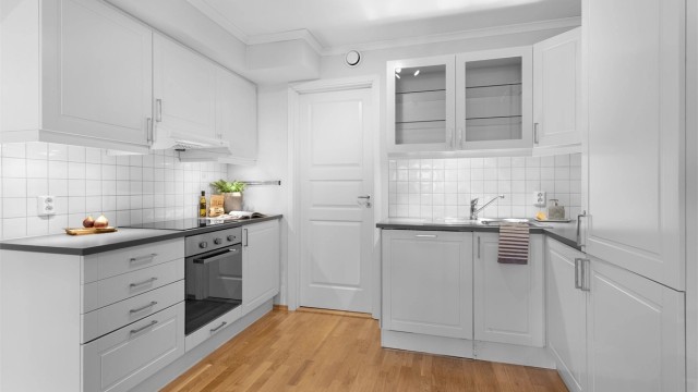 Kjøkken med innredning med profilerte fronter. Benkeplate med laminert overflate med nedfelt kjøkkenvask.