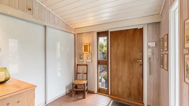 Romslig entré med flislagt gulv, gulvvarme og en stor skyvedørsgarderobe for effektiv oppbevaring.