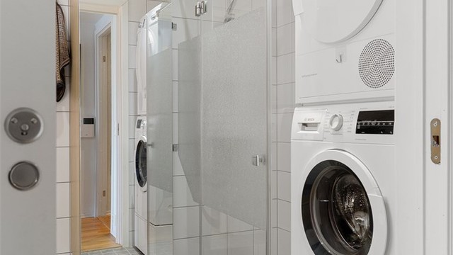 Badet har en meget romslig dusj og opplegg for vaskemaskin og tørketrommel i søyle.