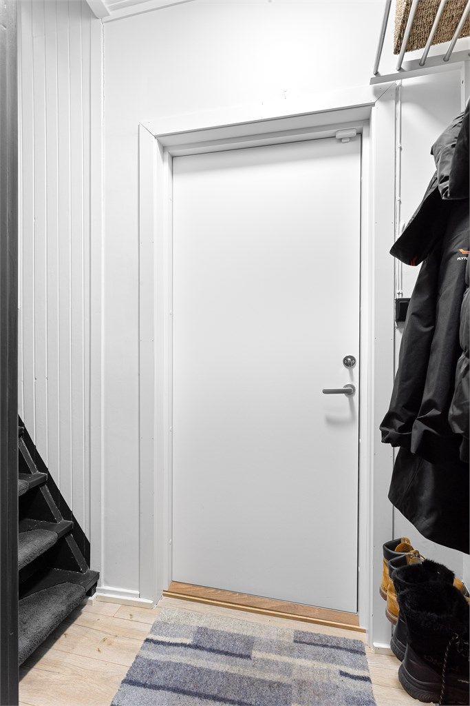 Entréen har plass til oppheng av yttertøy og trapp opp til andre etasje.