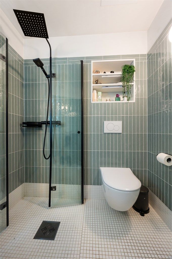 Badet er innredet med vegghengt toalett og egen dusjsone med innfellbare glassdører.