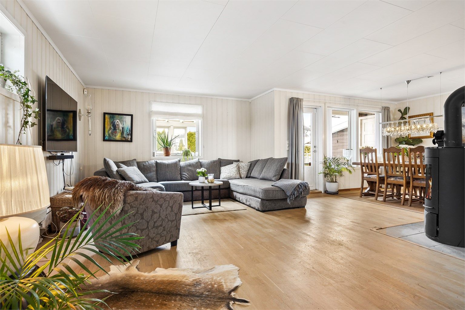 Rommet har panel på veggene og parkett på gulvet, noe som skaper en lun atmosfære.