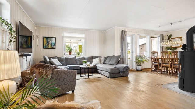 Rommet har panel på veggene og parkett på gulvet, noe som skaper en lun atmosfære.