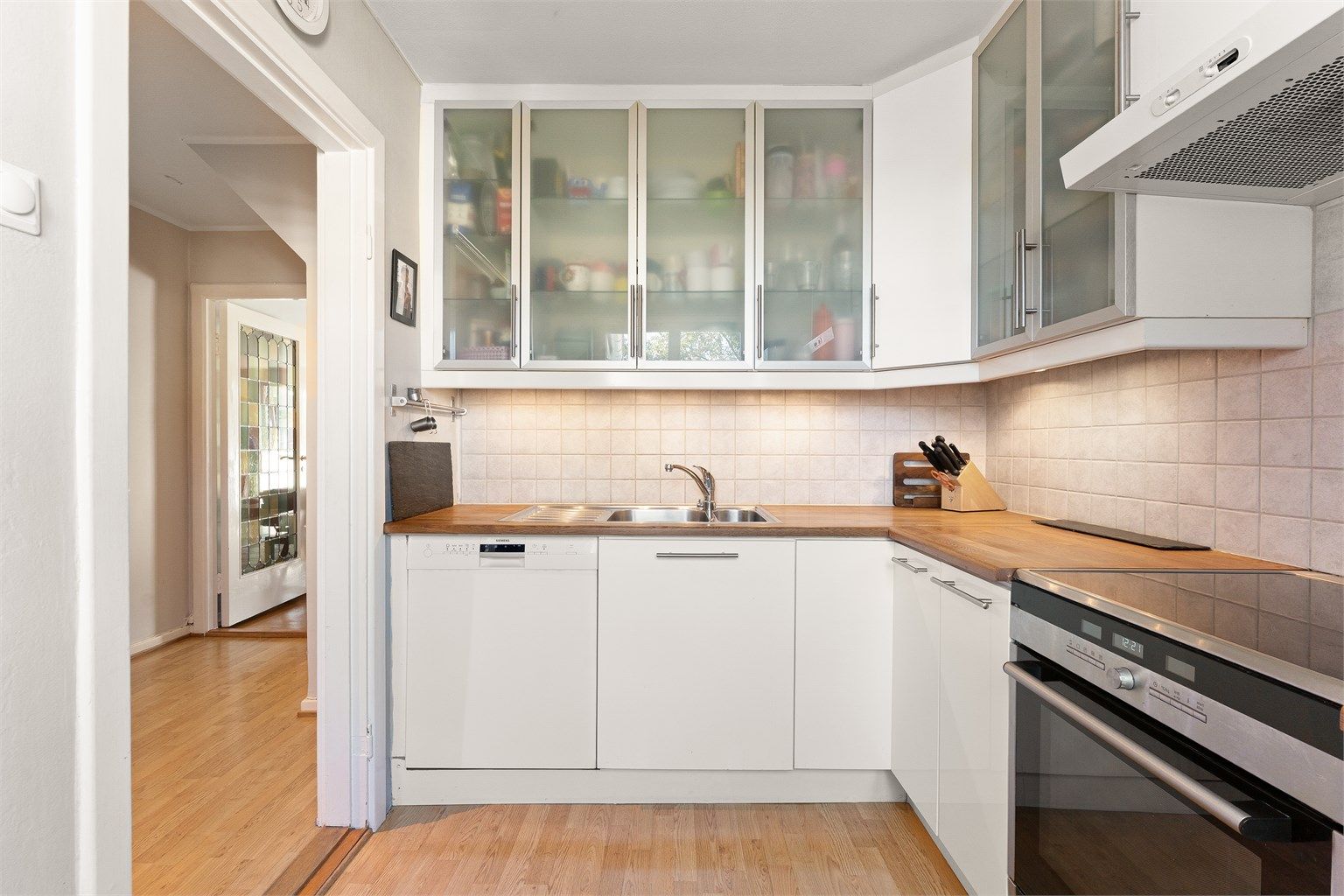 Kjøkkeninnredningen har en kombinasjon av hvite fronter og vitrineskap.