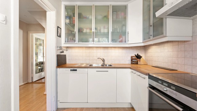 Kjøkkeninnredningen har en kombinasjon av hvite fronter og vitrineskap.