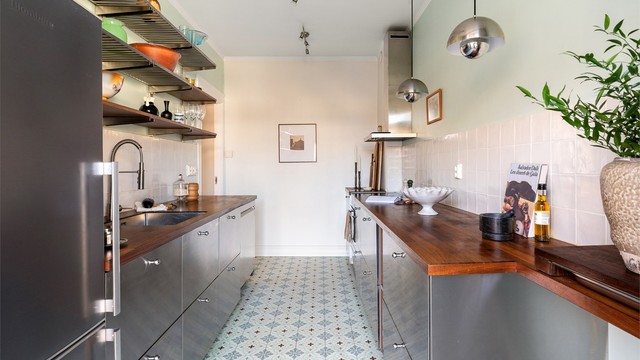 Kjøkkenet ble stilrent oppgradert i 2022, med fronter i metall og en solid benkeplate i heltre. Herfra er det direkte utgang til balkongen.