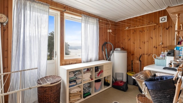 Praktisk vaskerom i underetasjen med utslagsvask og opplegg for vaskemaskin. Det er direkte utgang til hagen- en smart løsning etter hagearbeid eller andre utendørsaktiviteter