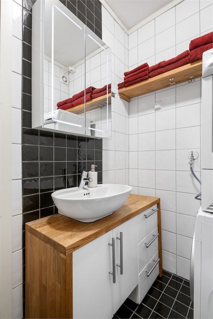 Kjekk baderomsinnredning og vegghengt speilskap med integrert belysning og stikkontakt.
