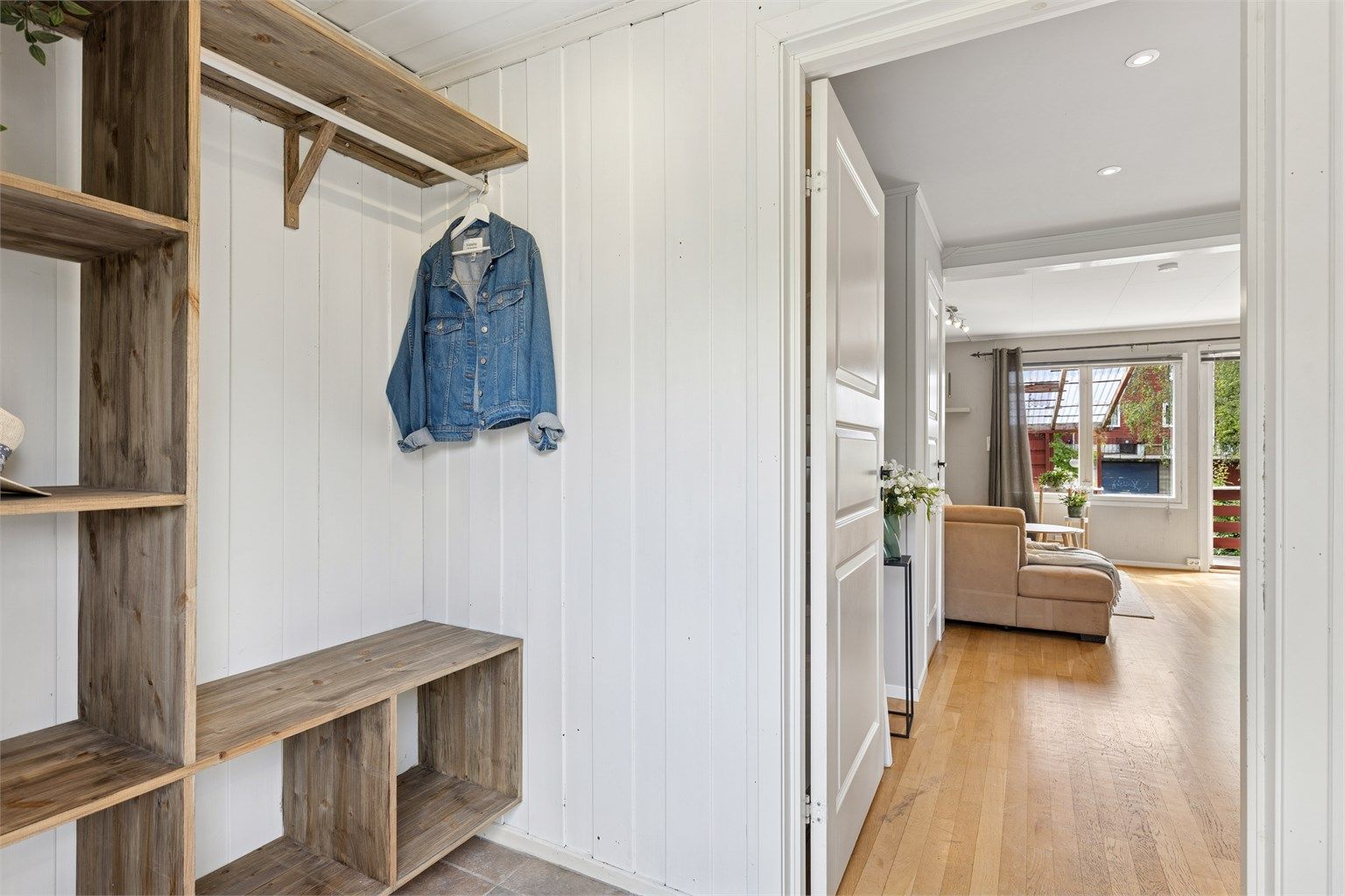 Hyggelig entré med flislagt gulv med gulvvarme. Her er det godt med hyller for yttertøy og sko