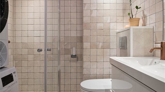 Baderom i underetasjen - Innredet med vegghengt klosett, servant med innredning, innfelt speil og dusj med svingbare glassdører.