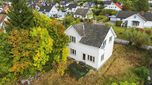 Utvendig har boligen en eldre hovedfasade kledd med eternittplater og tilbygg med liggende trekledning.