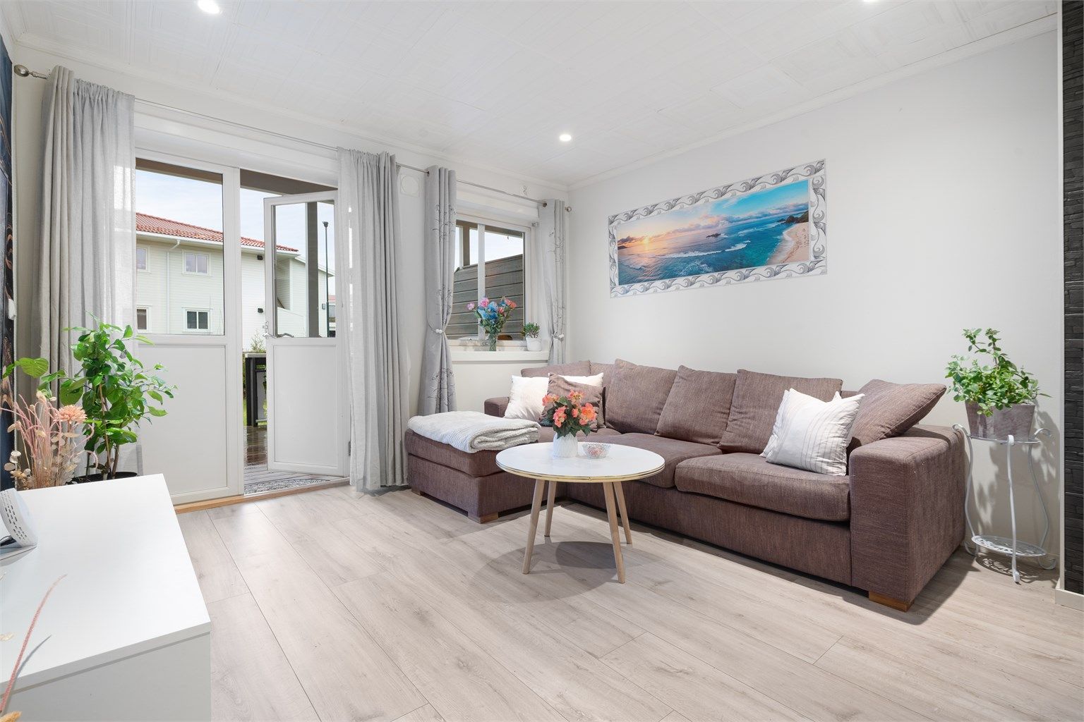 I stuen er det downlghts i taket, malte overflater på vegger og gulvflater med laminat