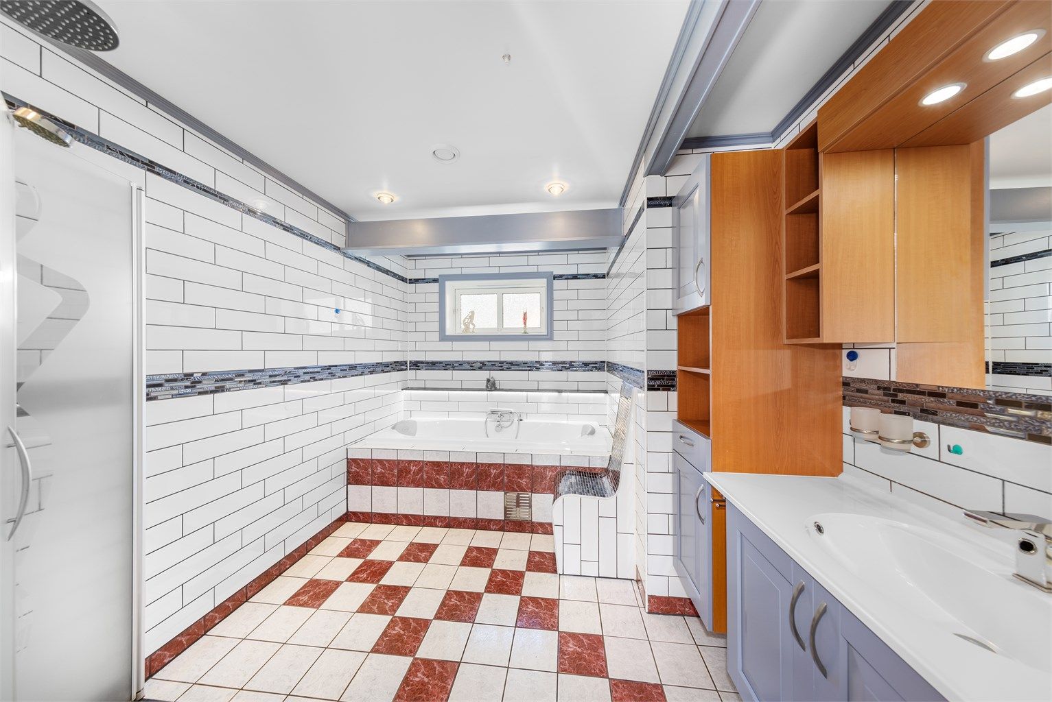 På badet er det flislagt stol som står i stil til dekorflis. Badekaret er inmurt.