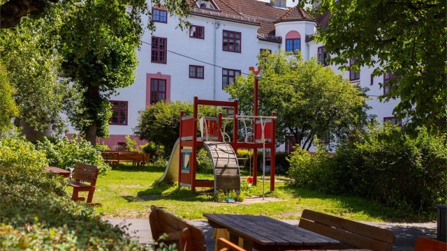 Store grøntområder, sitteplasser og frodig beplantning gjør bakgården til et naturlig samlingssted gjennom hele året.