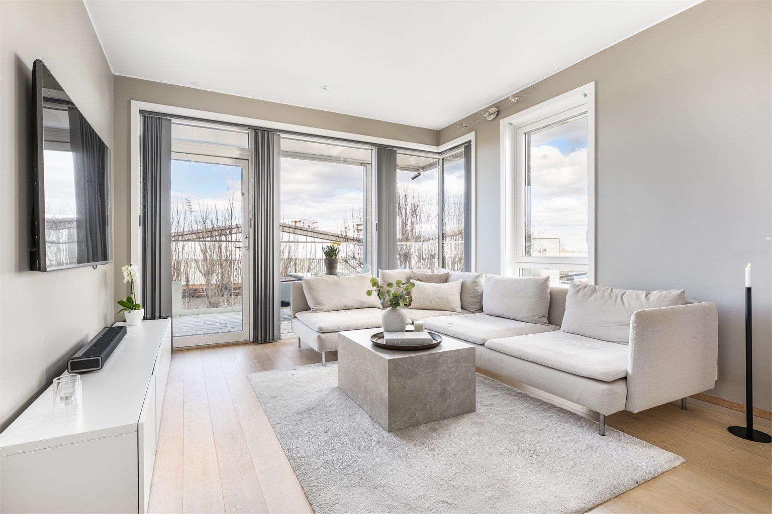 Vertikalstilte vinduer gir meget gode lysforhold i stuen og fremhever i tillegg den ekstra store himlingshøyden på nær 2,7 meter.