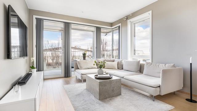 Vertikalstilte vinduer gir meget gode lysforhold i stuen og fremhever i tillegg den ekstra store himlingshøyden på nær 2,7 meter.