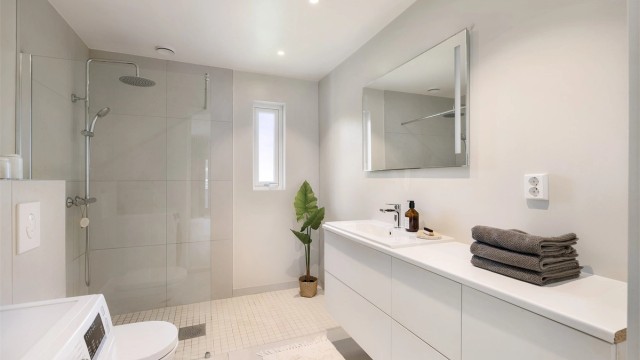 Badet har elektrisk gulvvarme, downlights i taket og opplegg for vaskemaskin. Et lekkert og innbydende bad.