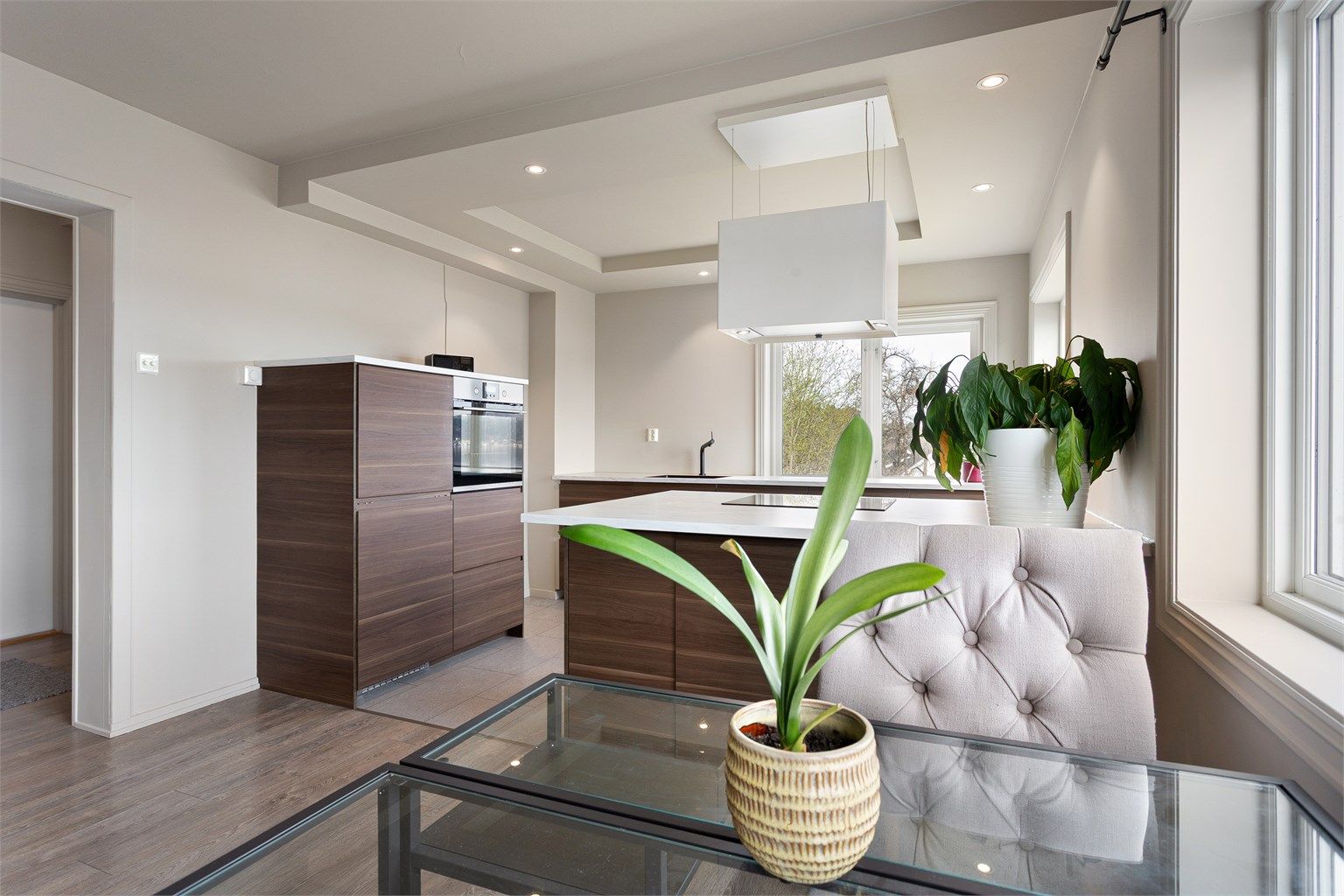 Høyskap med integrert stekeovn og kjøleskap gir en ryddig og funksjonell sone for matlaging.