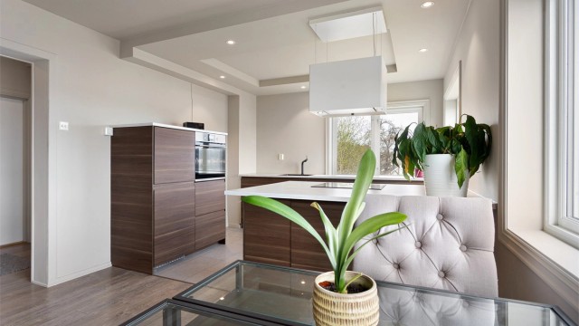 Høyskap med integrert stekeovn og kjøleskap gir en ryddig og funksjonell sone for matlaging.