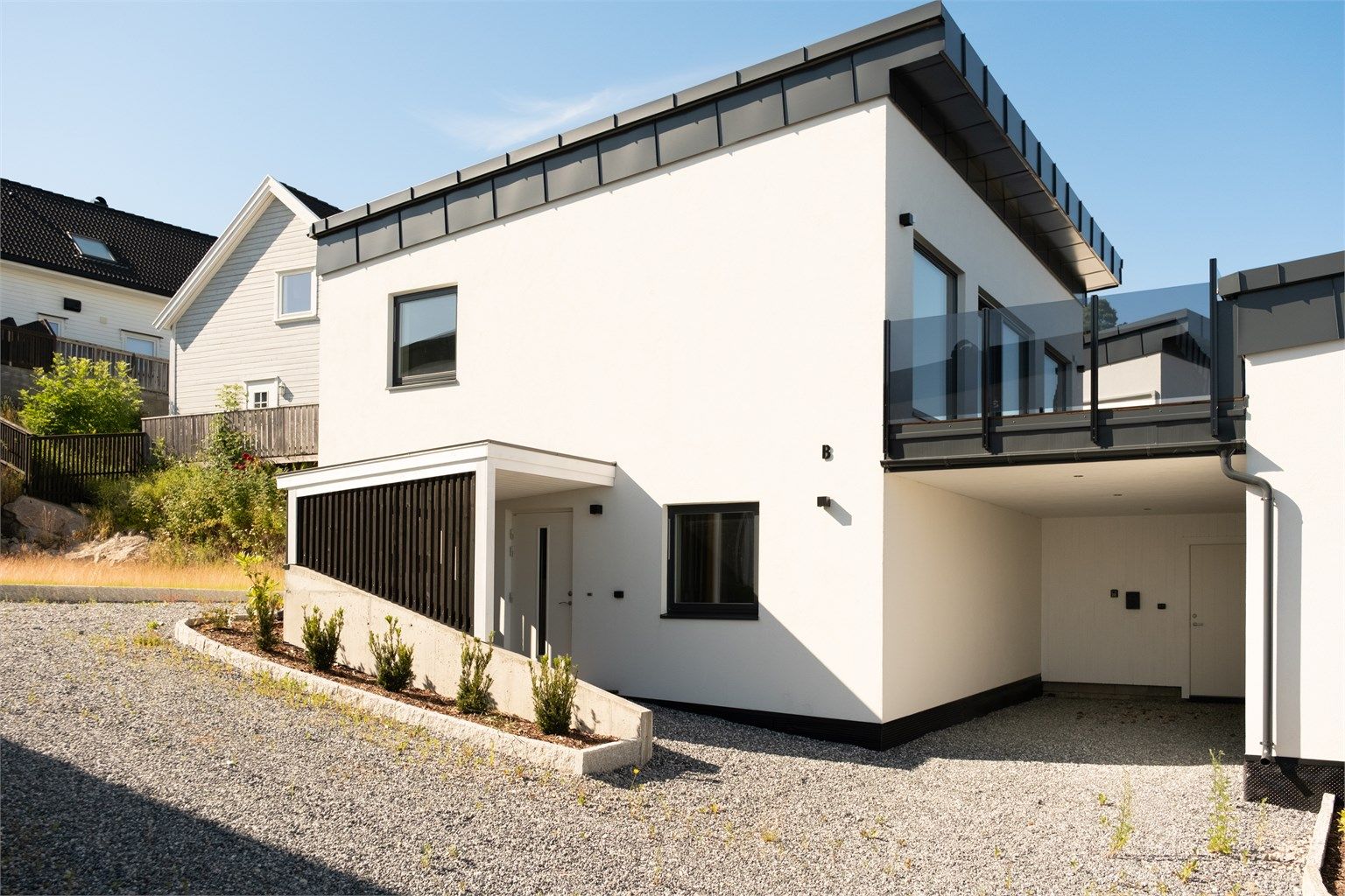 I carport er det oppstillingsmulighet for én bil. Boligen får ytterligere én oppstillingsplass ovenfor inngangspartiet.