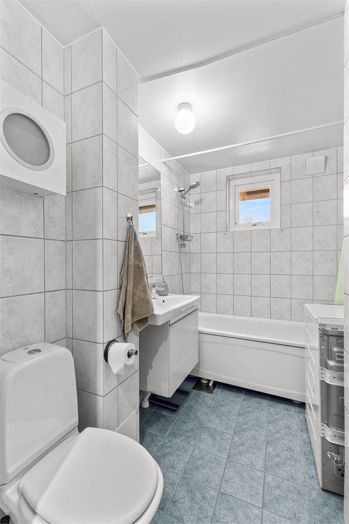 Velfungerende felles vaskeri i kjelleren. Badet er utstyrt med heldekkende servant på underskap, servant, klosett og badekar. 