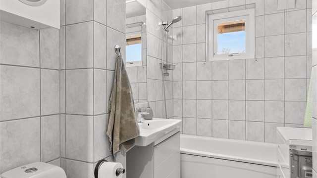 Velfungerende felles vaskeri i kjelleren. Badet er utstyrt med heldekkende servant på underskap, servant, klosett og badekar.