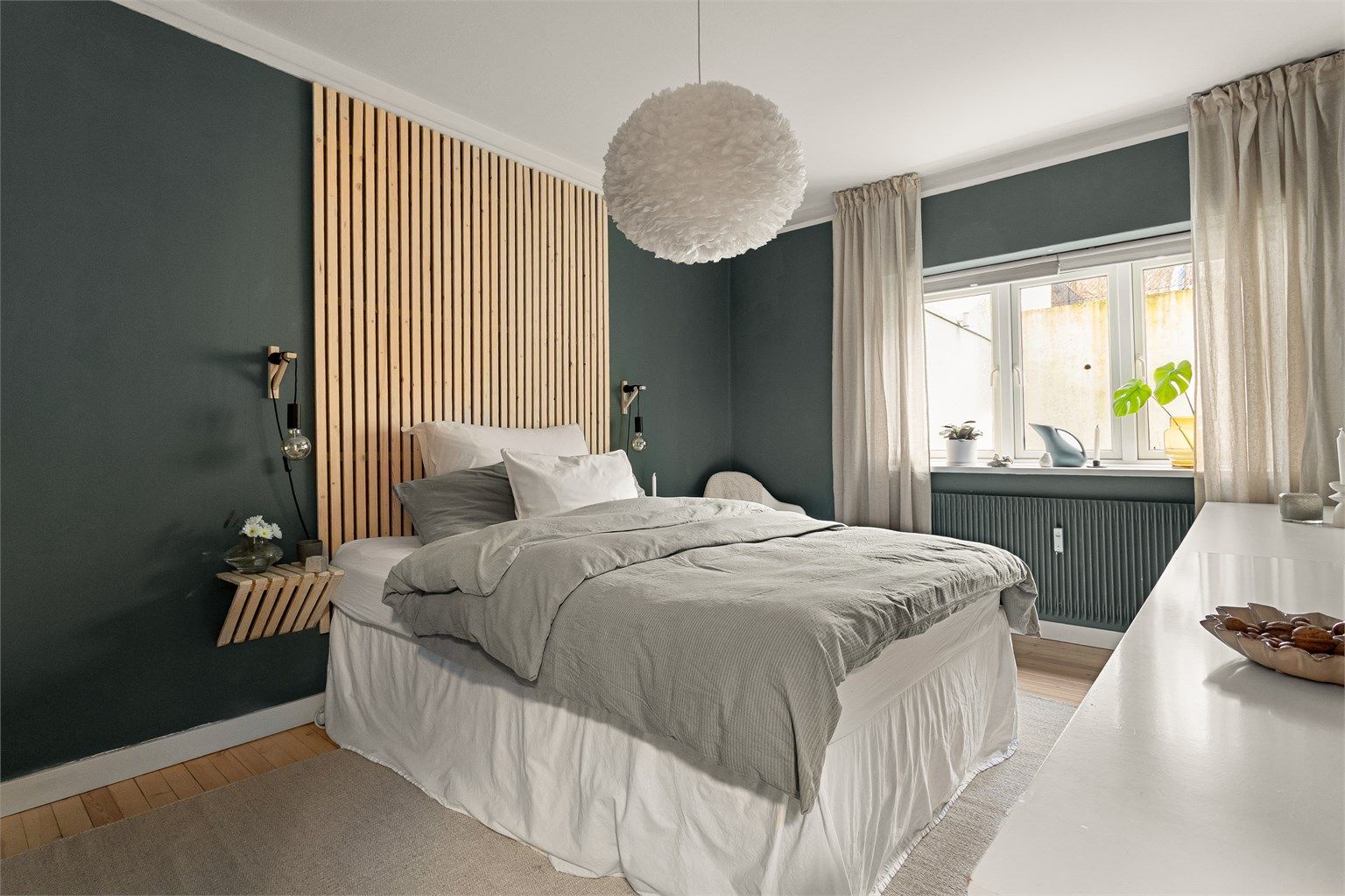 Boligens hovedsoverom er lyst og luftig, med god plass til dobbeltseng og tilhørende møblement.