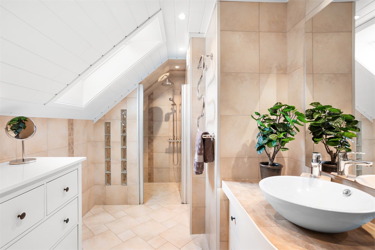 Delikat og innbydende baderom fra 2012 med gulvvarme, takvindu, romslig dusjnisje og moderne innredning.