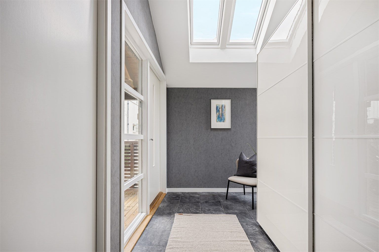 Romslig entré med belegg på gulv, varmekabler i gulv, tapet på vegg og garderobeskap med oppbevaringsplass. Inngangspartiet har meget god takhøyde og store takvindu, som gir en ekstra rom romfølelse. 