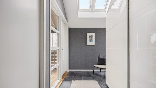 Romslig entré med belegg på gulv, varmekabler i gulv, tapet på vegg og garderobeskap med oppbevaringsplass. Inngangspartiet har meget god takhøyde og store takvindu, som gir en ekstra rom romfølelse.