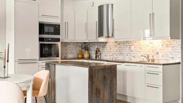 Moderne og funksjonell kjøkkeninnredning med integrerte hvitevarer og praktisk kjøkkenøy. Slette fronter kombinert med treverk gir et tidløst uttrykk. God belysning og smarte løsninger sikrer en behagelig arbeidssone.