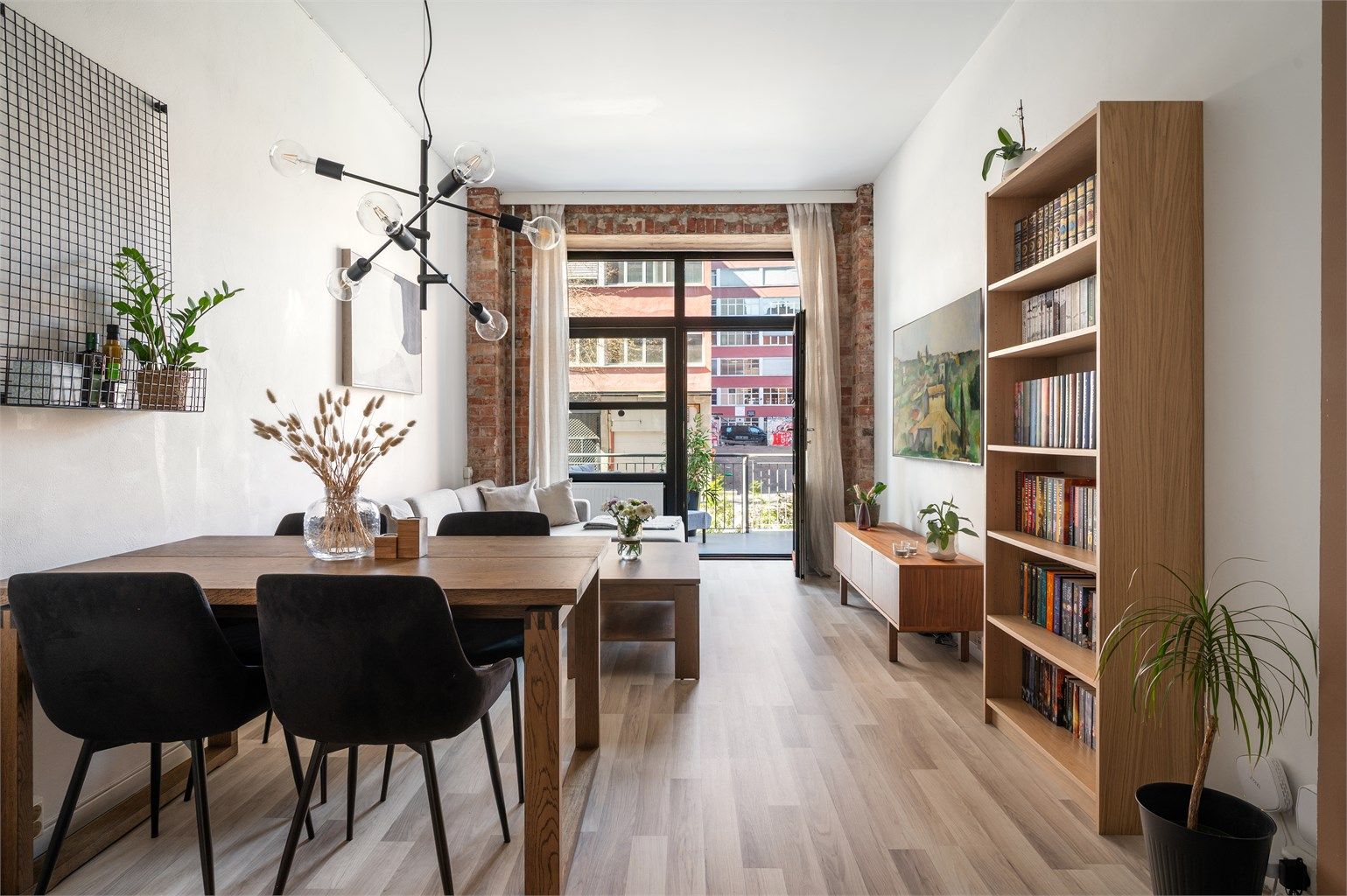 I stuen har du plass til sofa, sofabord, tv-benk m.m. Veggen mot terrassen er dekket av sjarmerende murstein som står i stil med resten av det historiske fabrikkbygget.