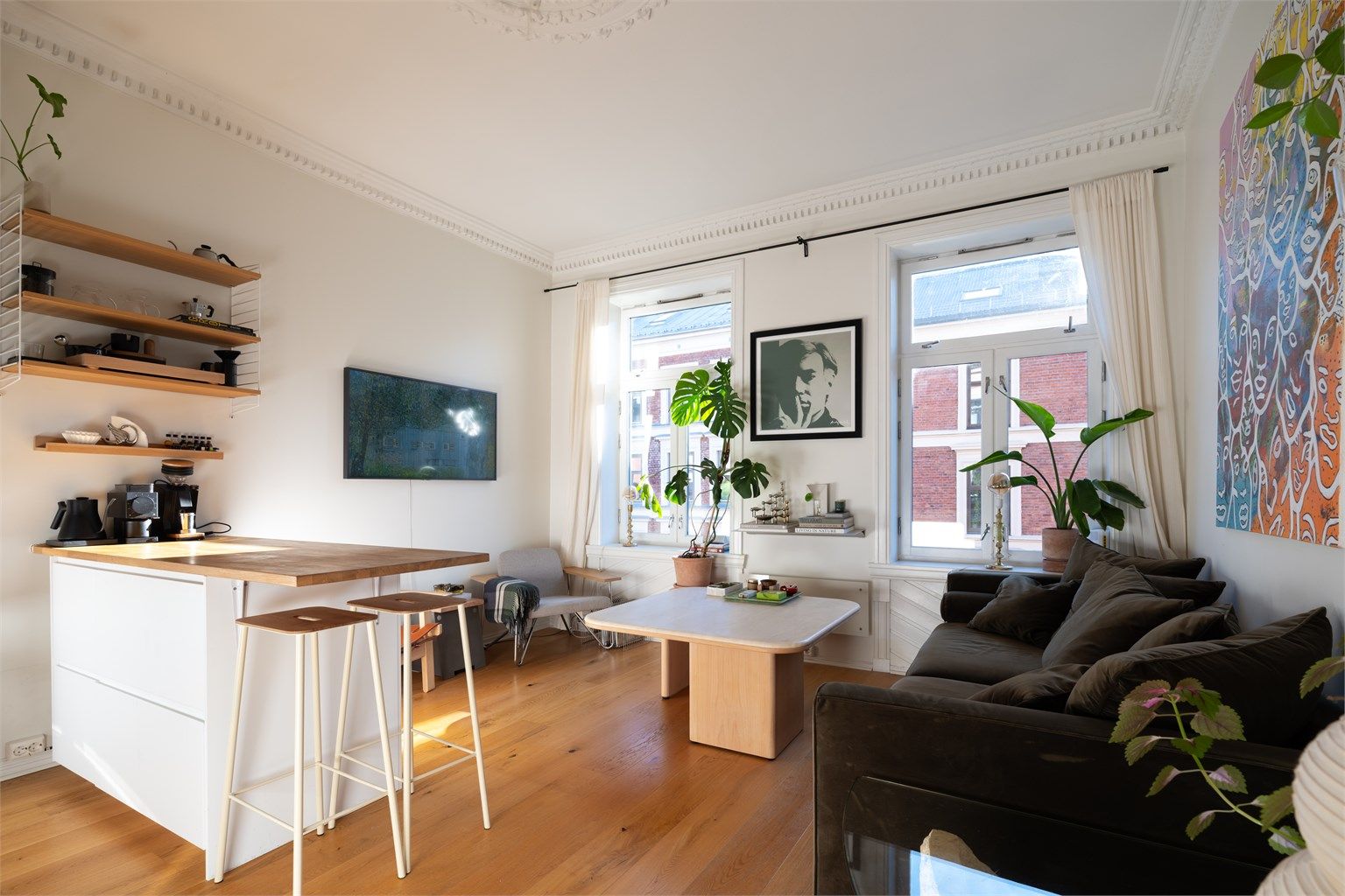 Stuen er romslig og har en takhøyde på hele 2,76 meter, noe som sammen med store vindusflater skaper en luftig og behagelig atmosfære med rikelig naturlig lys.