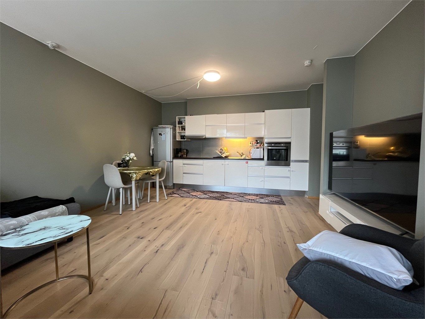 Stue med plass til både spisebord og sofadel. Pent kjøkken med hvitevarer. 