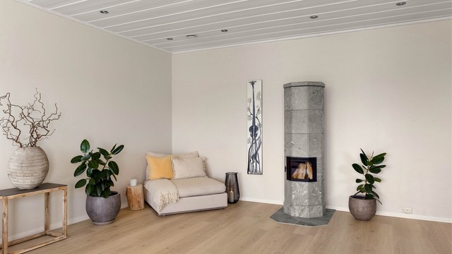 Gjennomgående materialvalg med malt panel i himling og lyse gulv gir boligen et helhetlig og tidløst uttrykk.