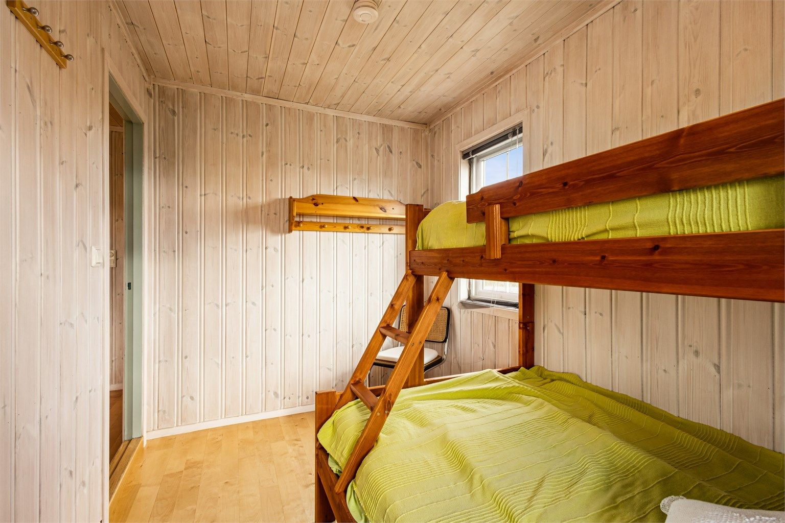 Gjennomgående trefinish på vegger og himling også på dette soverommet.