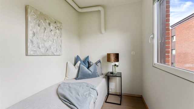Soverom med plass til seng og oppbevaringsmøbel.