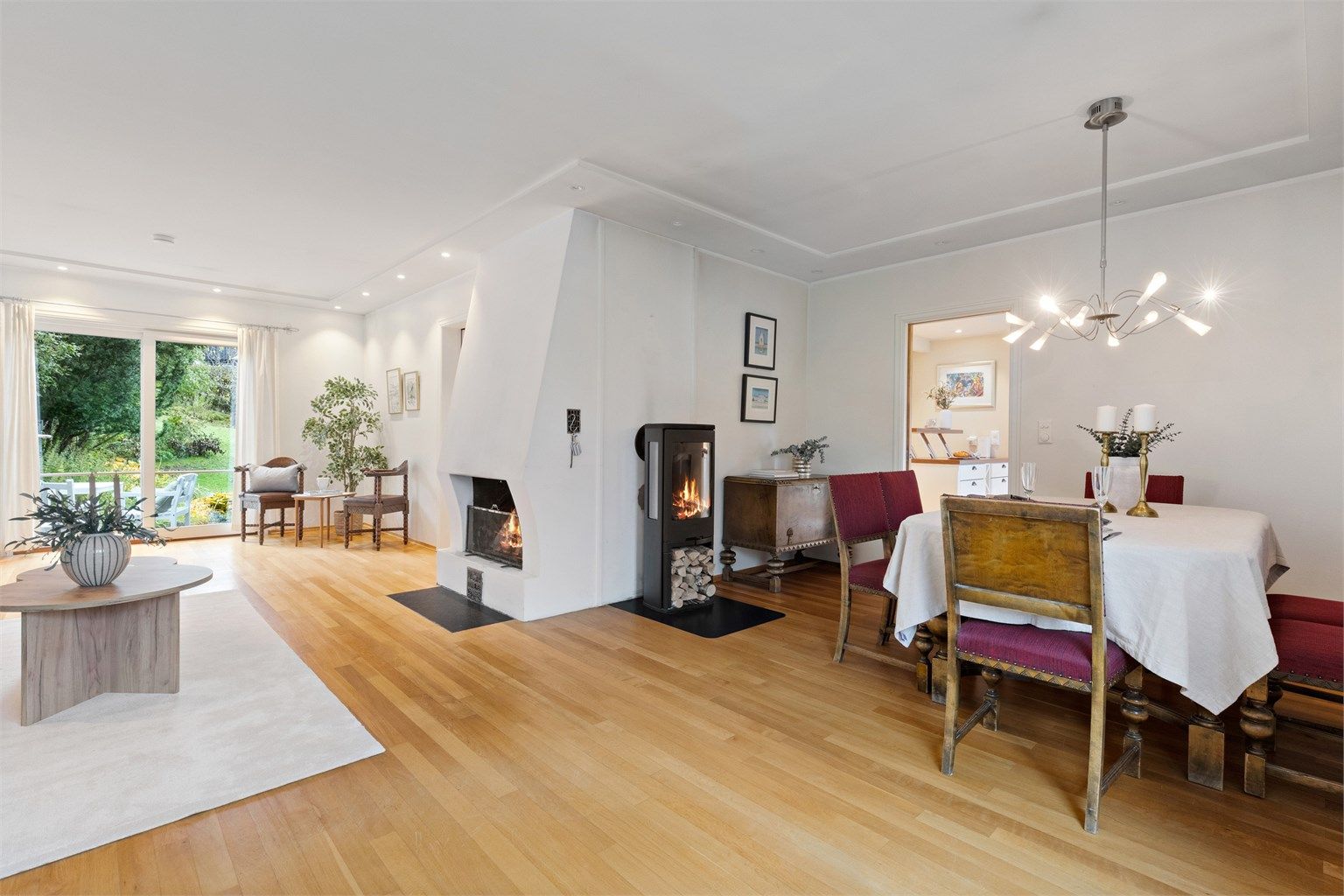 Romslig og lys vinkelstue med sofaområde, sittegruppe samt spiseplass