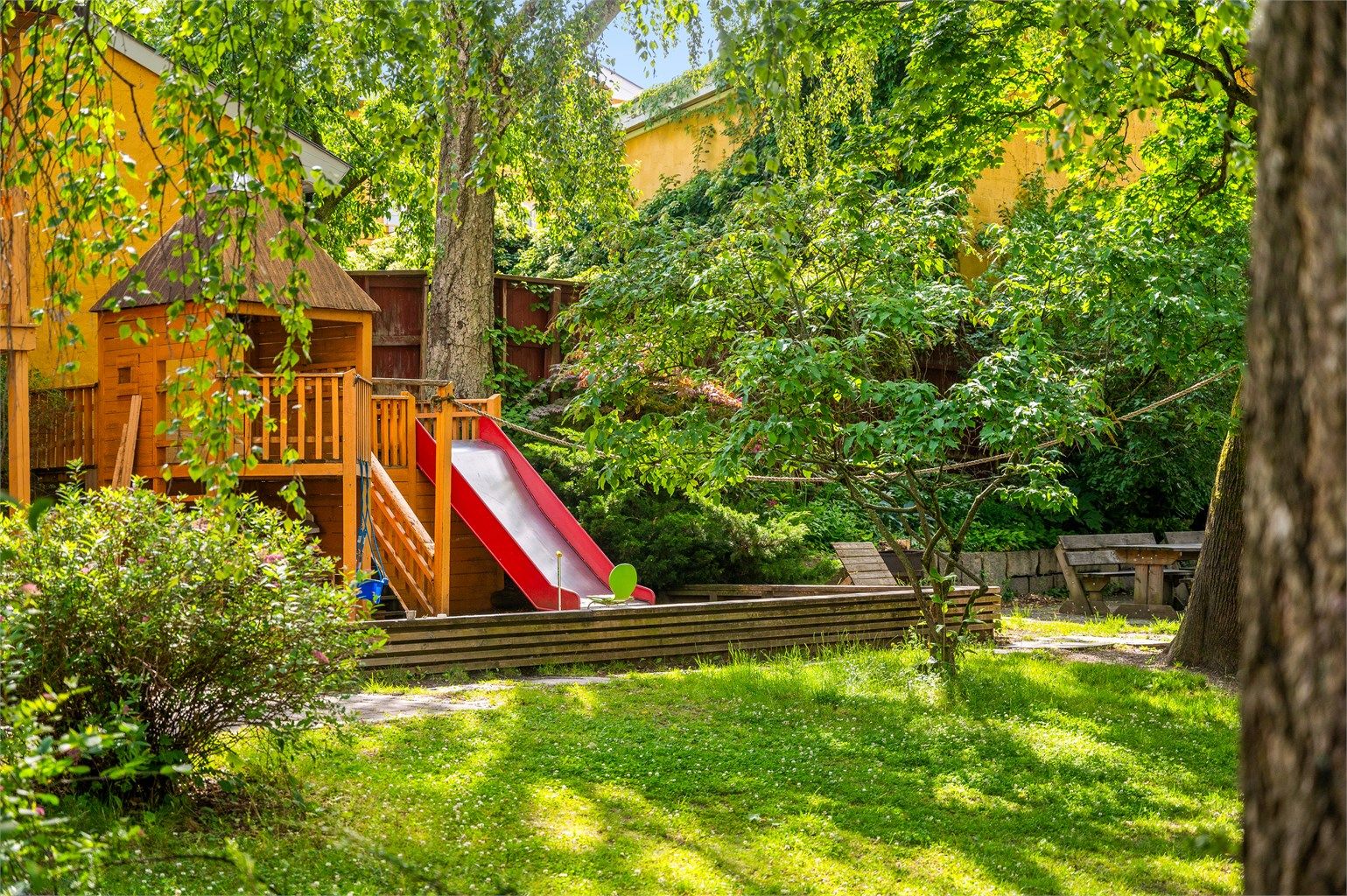 Lekeplassen ligger trygt til på innsiden av tunet, skjermet fra trafikk.